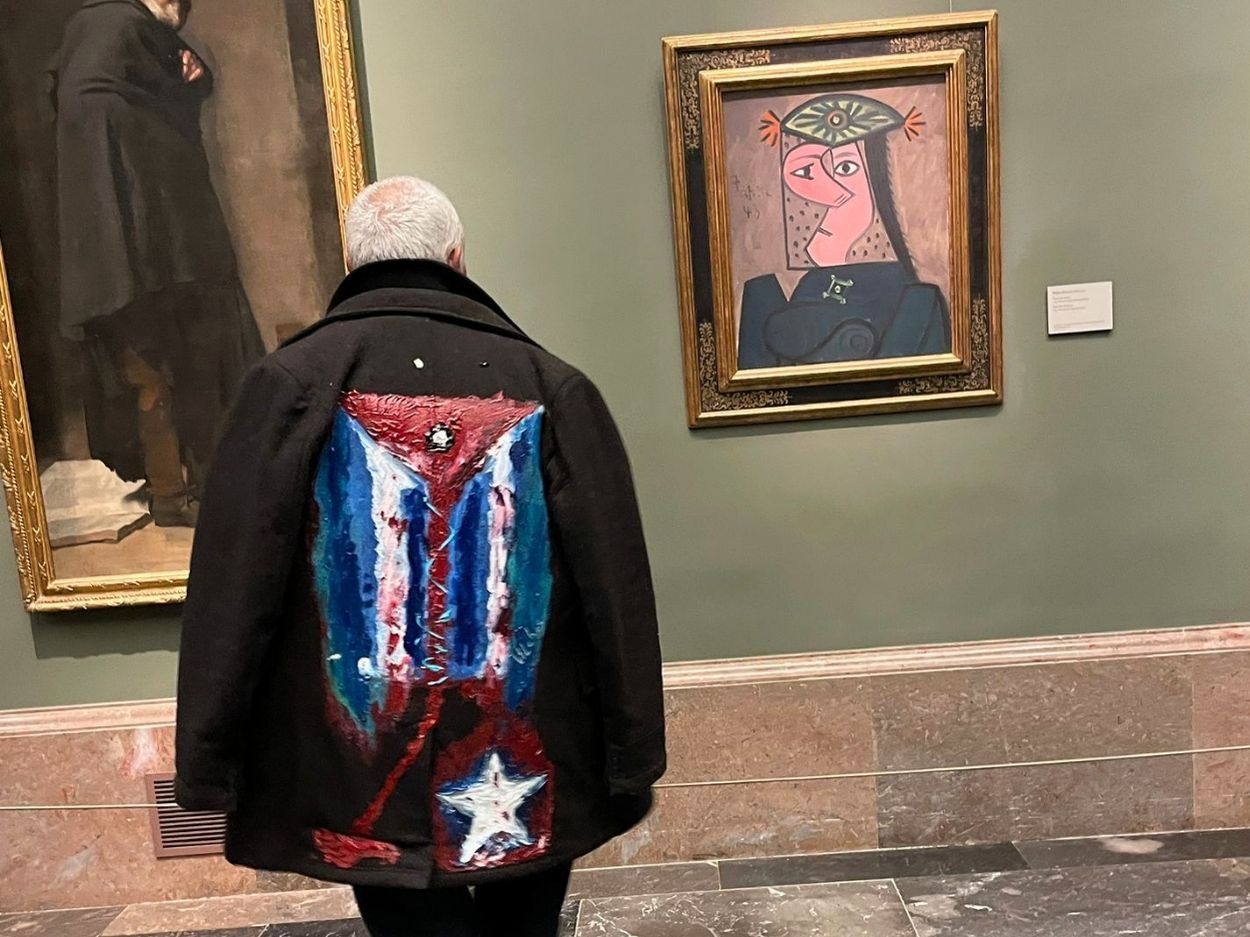 Perfomance "Mi bandera", del artista cubano exiliado Rafael Vilches. El artivista cubano Rigoberto Carceller frente al cuadro "Busto de mujer" (1943) de Pablo Picasso en el Museo del Prado (23 de marzo de 2026). Foto de Ana Rosa Díaz Naranjo.