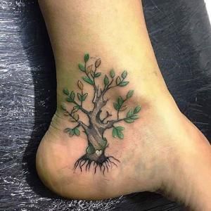 Árbol tatuado en tobillo.