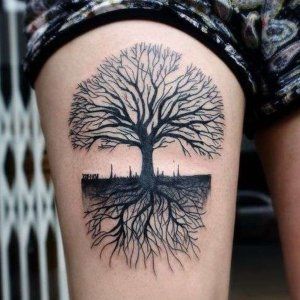 Tatuaje de un árbol en la pierna.