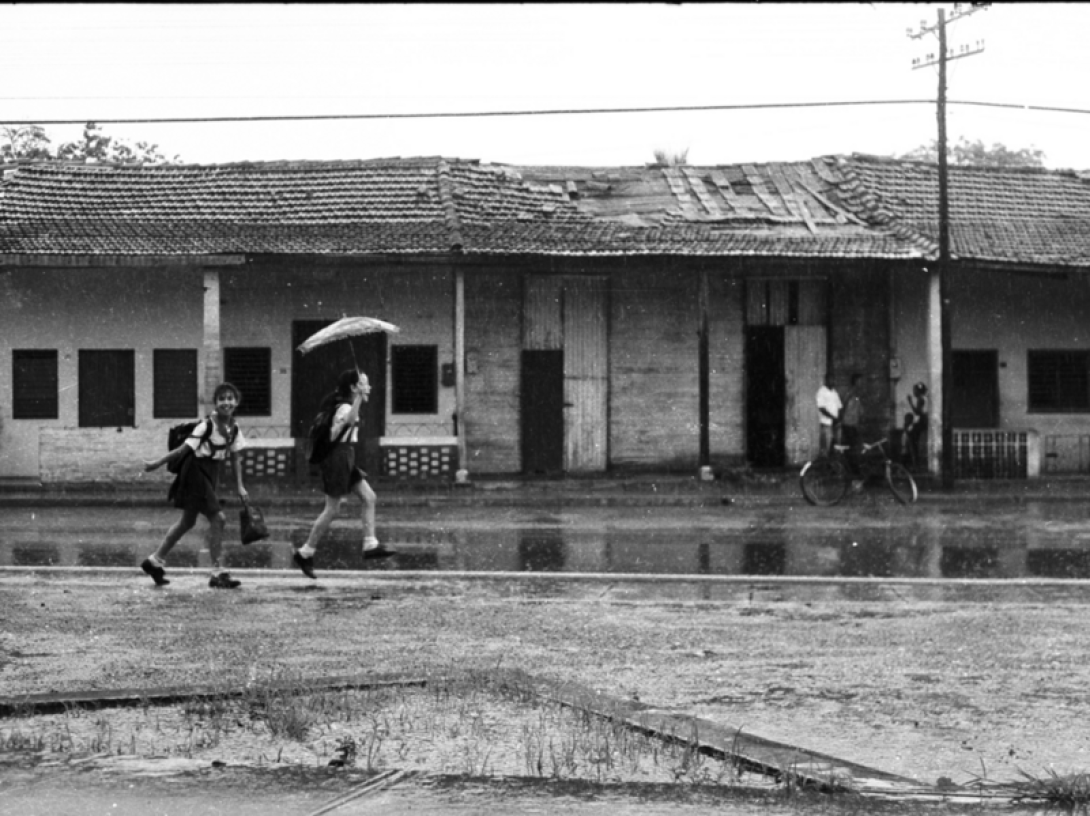 Niñas caminando alegres bajo la lluvia. 