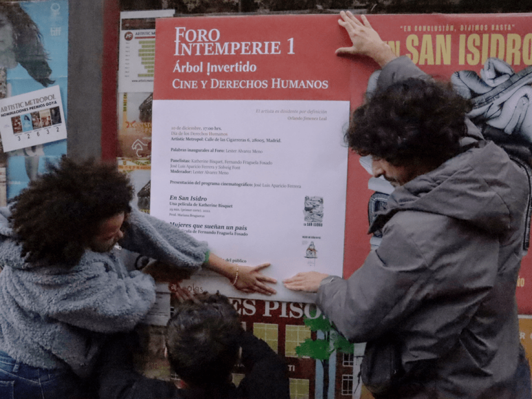 Yanelis Núnez y Julio Llópiz Casal pegando el cartel del Foro Intemperie.