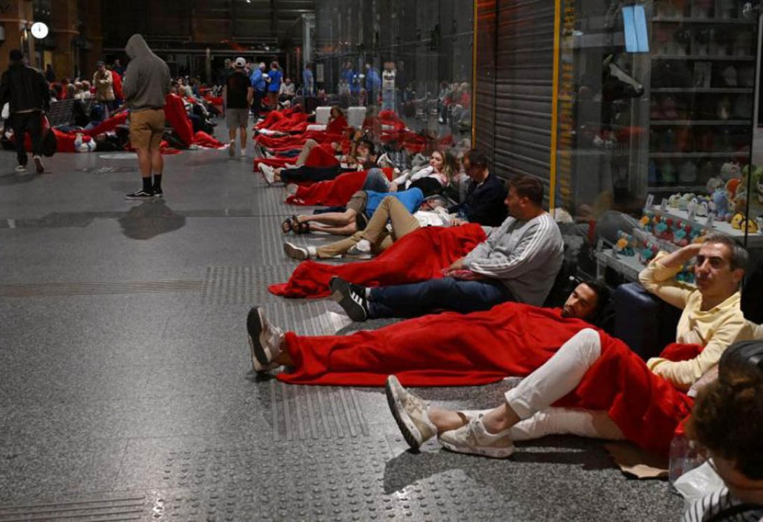 Viajeros preparándose para pasar la noche en la estación de tren de Córdoba.