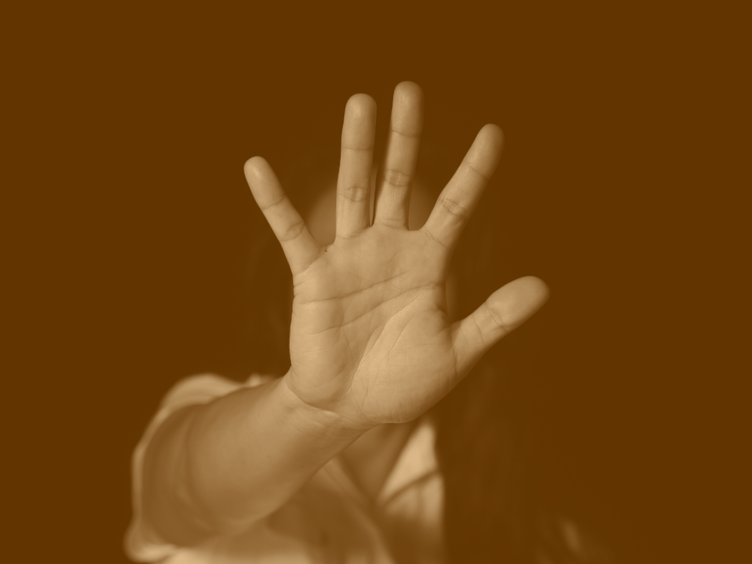 Contra la violencia hacia la mujer: Mujer pone su mano delante en señal de "stop".
