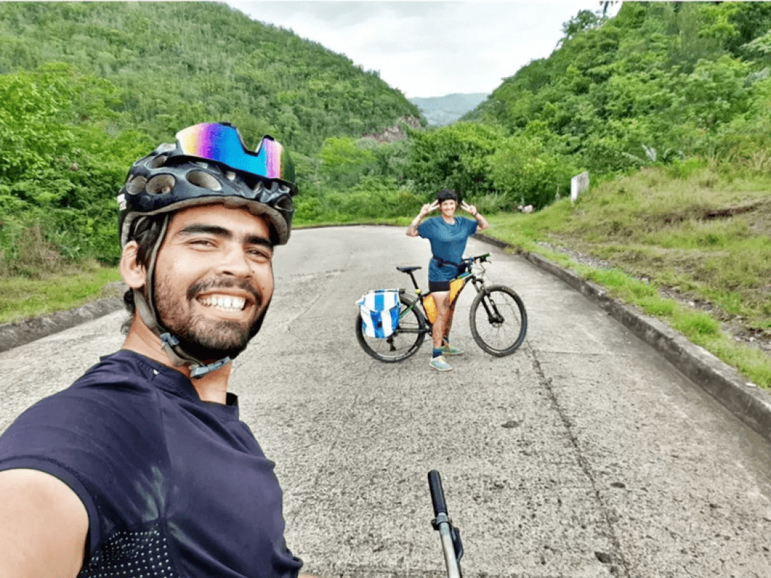 Yasnay y Miguel en bicicleta por Sagua De Temamo, Holguin, Cuba: al fondo las montañas y la vegetación cubana.
