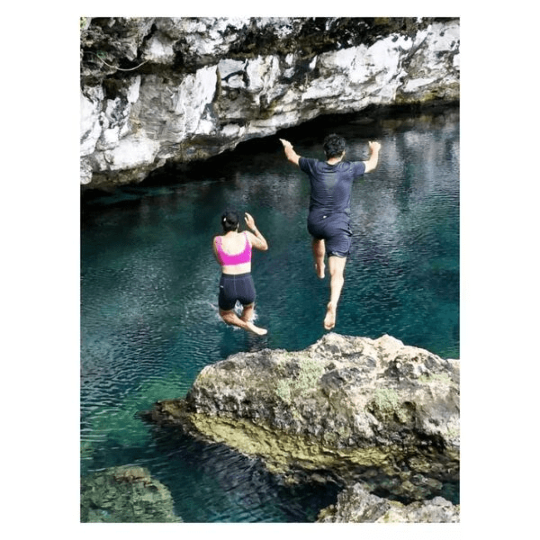 Yasnay y MIguel saltando a un lago en una cueva.