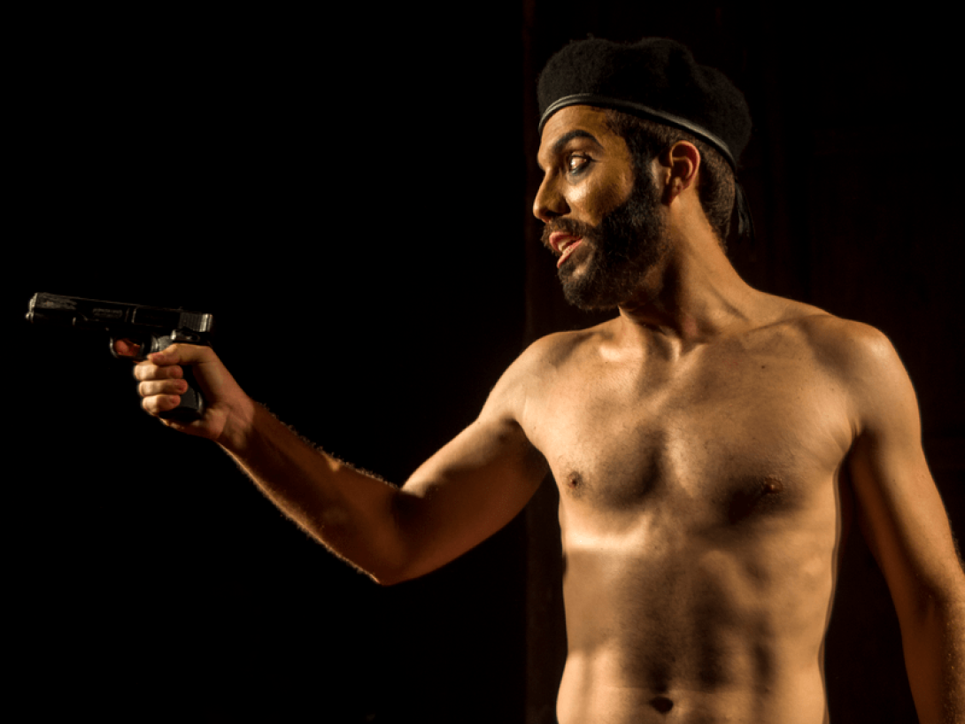 Actor en escena apunta con una pistola.