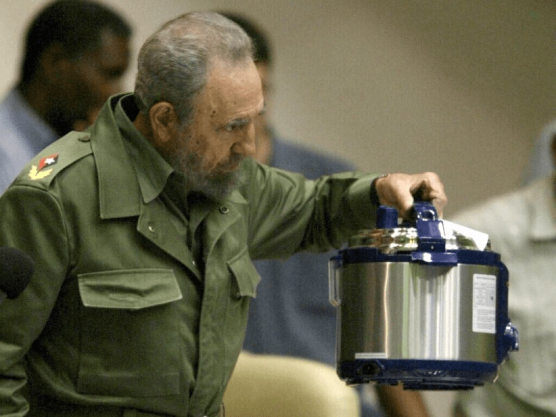 Fidel Castro sosteniendo una olla de cocina. 