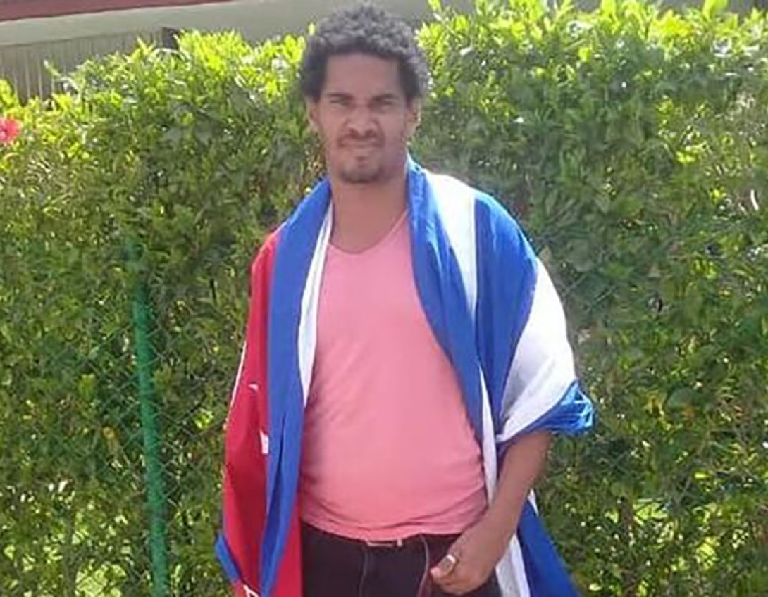 El artista Luis Manuel Otero Alcántara con la bandera cubana.