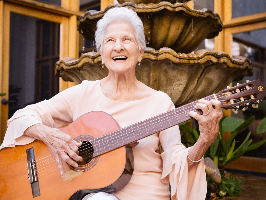 Ángela Álvarez sosteniendo su guitarra y sonriendo.