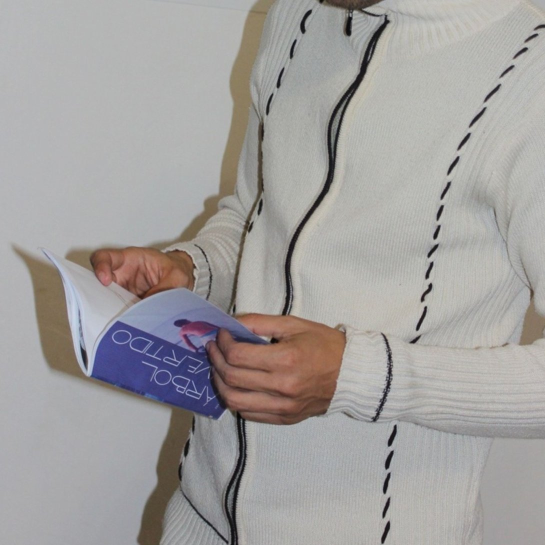 Lector ocasional leyendo un ejemplar de Árbol Invertido durante una acción de liberación en espacio cultural urbano.