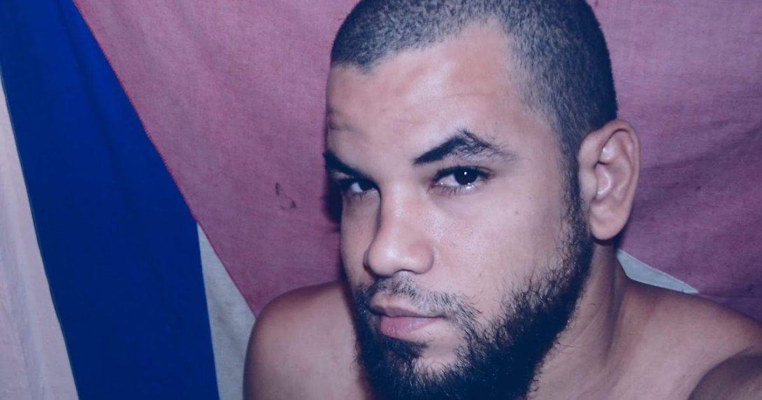 El poeta Ariel Maceo y la bandera cubana.