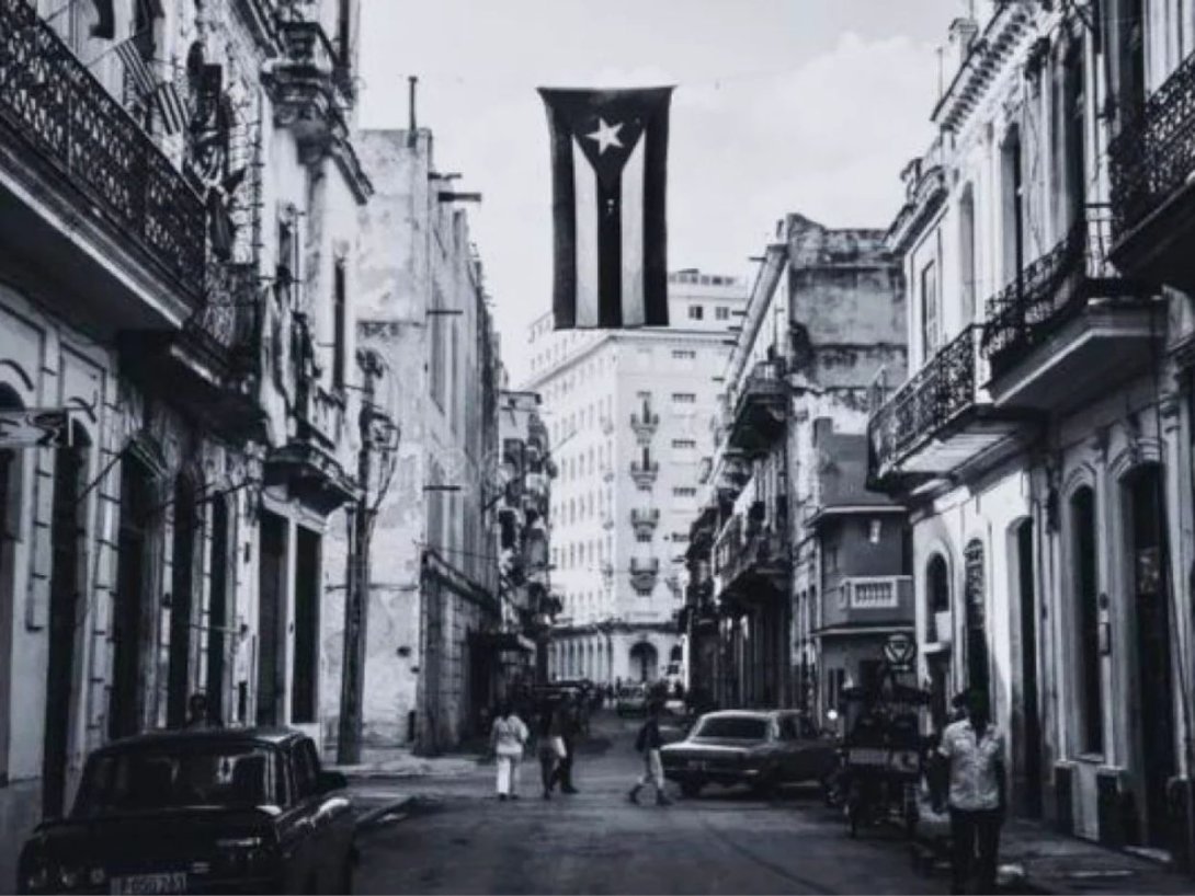 Bandera cubana colgada en medio de una calle habanera.