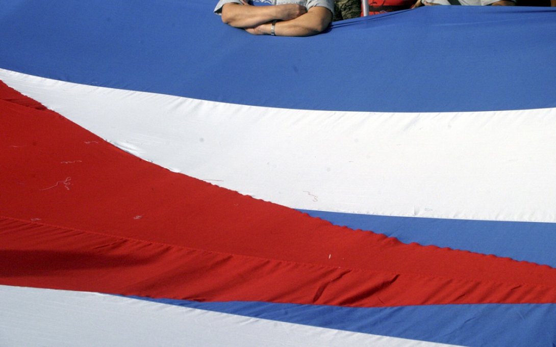 Hombre apoyado en la bandera cubana