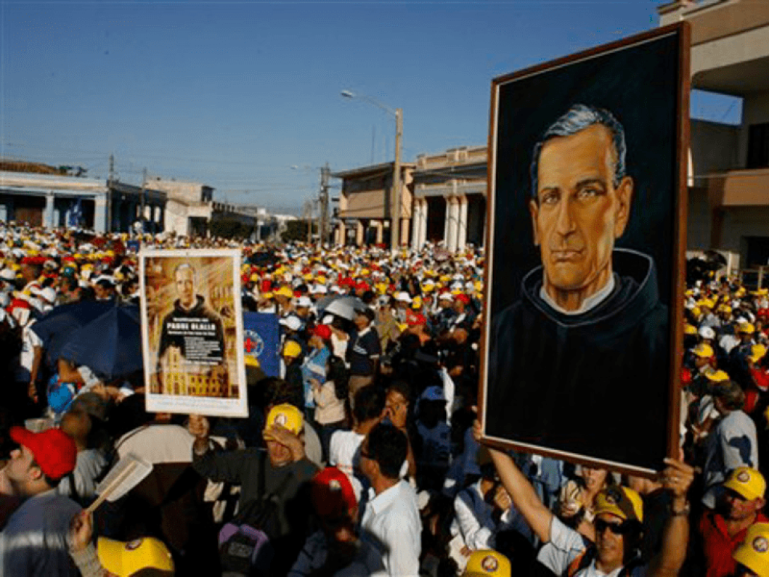 Personas alzan imágenes del padre Olallo en reunión popular ante la ceremonia de beatificación del mismo.