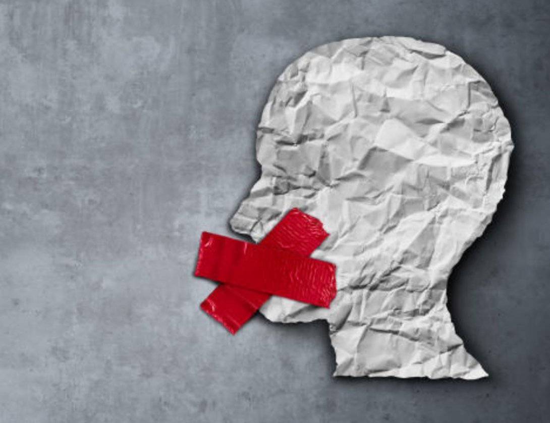 una cabeza de papel con una cruz en la boca