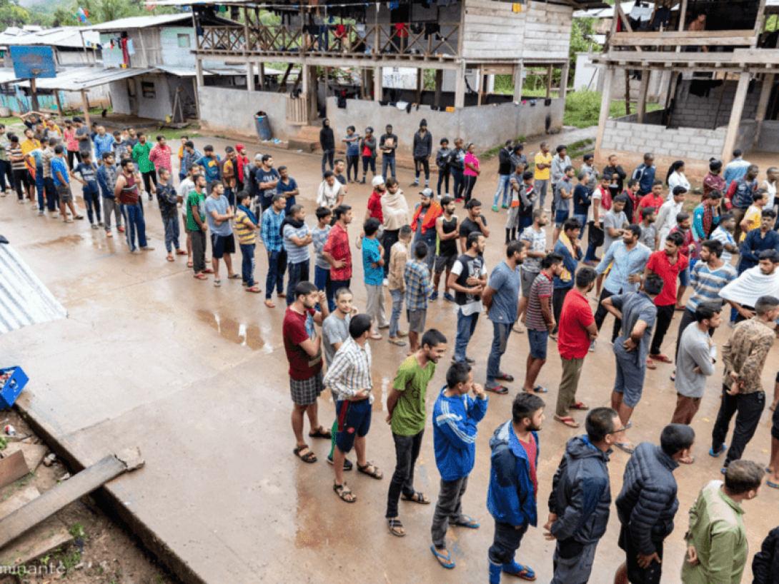 Larga fila de personas esperando mientras hacen la ruta hacia Estados Unidos por el Tapón del Darién.