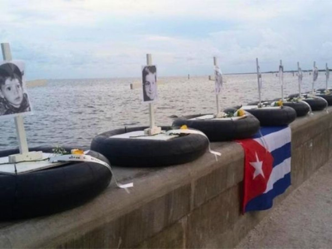 Homenaje en la bahía de Miami a las víctimas del hundimiento del remolcador 13 de Marzo, con retratos, cruces y una bandera cubana.