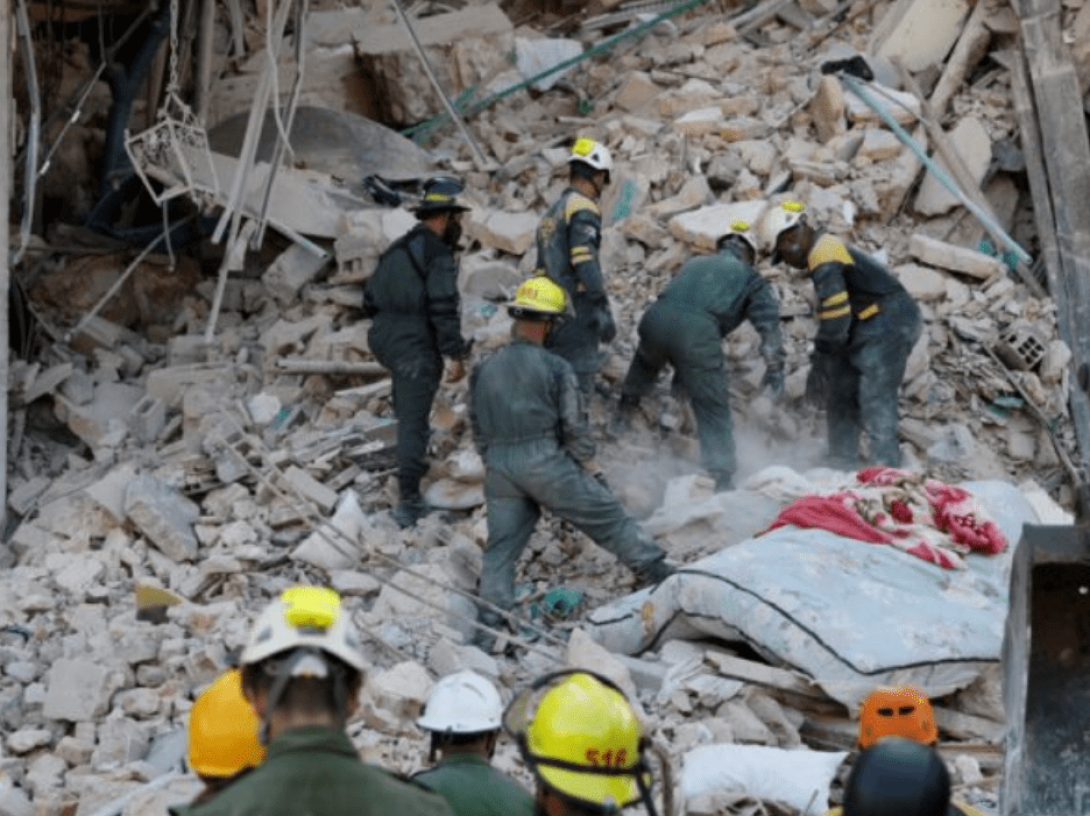 Bomberos buscando sobreviientes en los escombros.