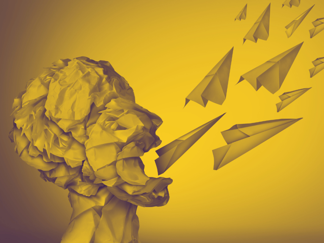 Cohetes de papel salen de la boca de una cabeza humana de papel.