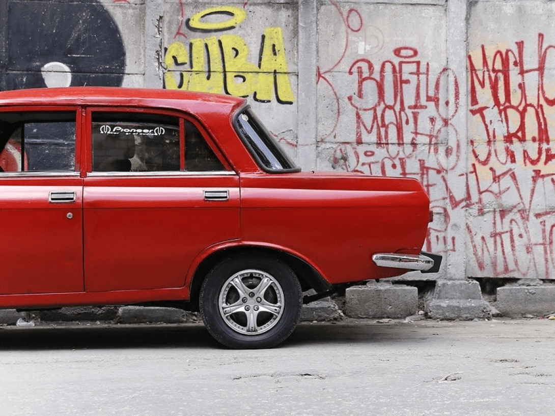 Carro antiguo soviético junto a pared con graffittis.