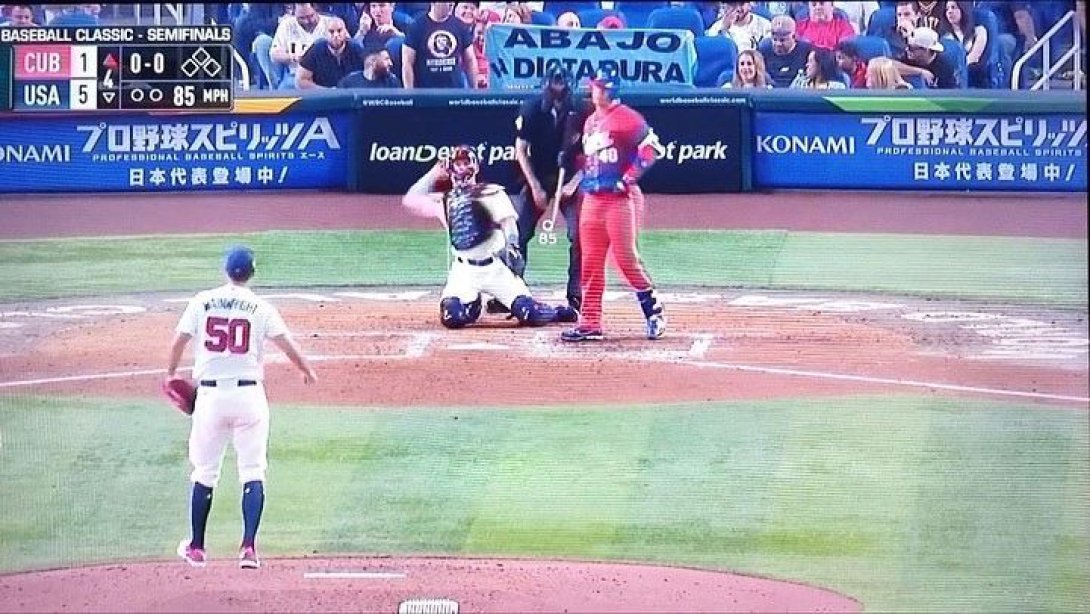Un cubano muestra un cartel contra la dictadura detrás del home plate.