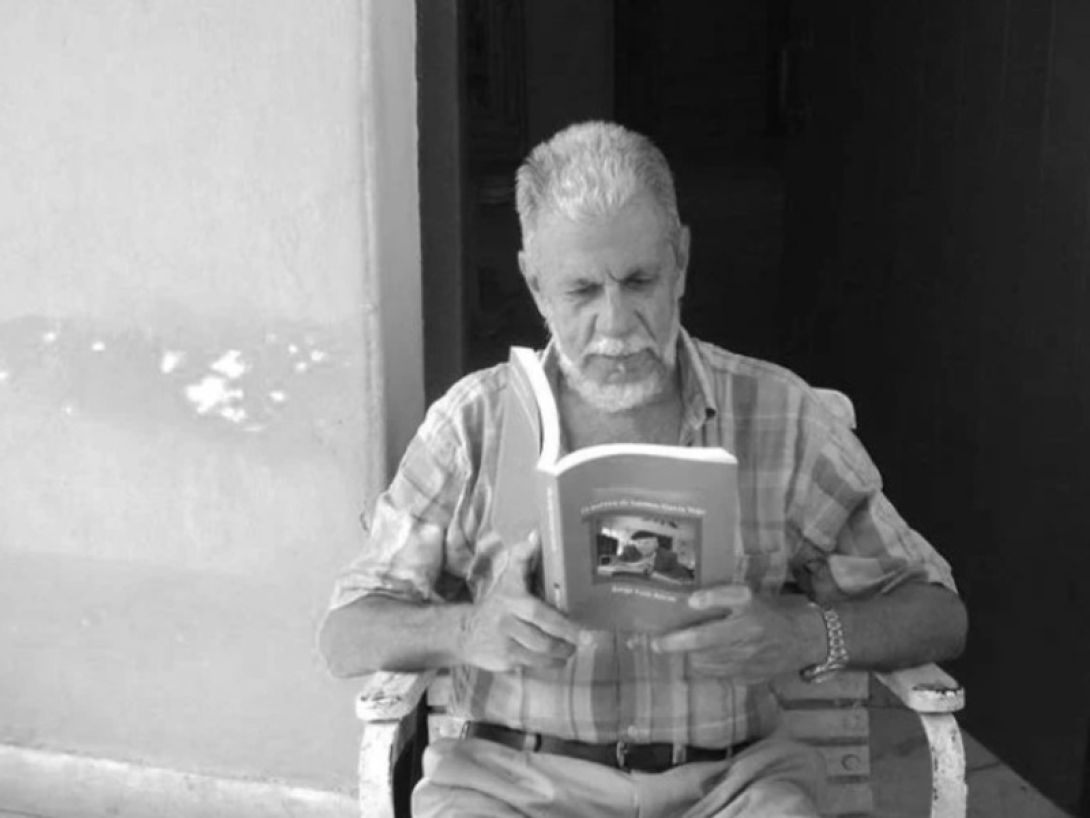 Hombre sentado leyendo un libro.
