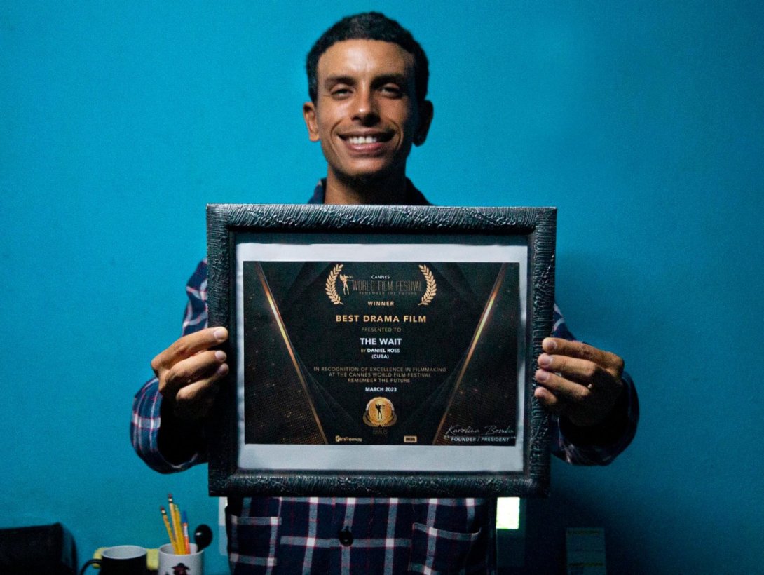 Daniel Ross Diéguez sosteniendo su diploma por haber ganado en el Cannes World Film Festival.