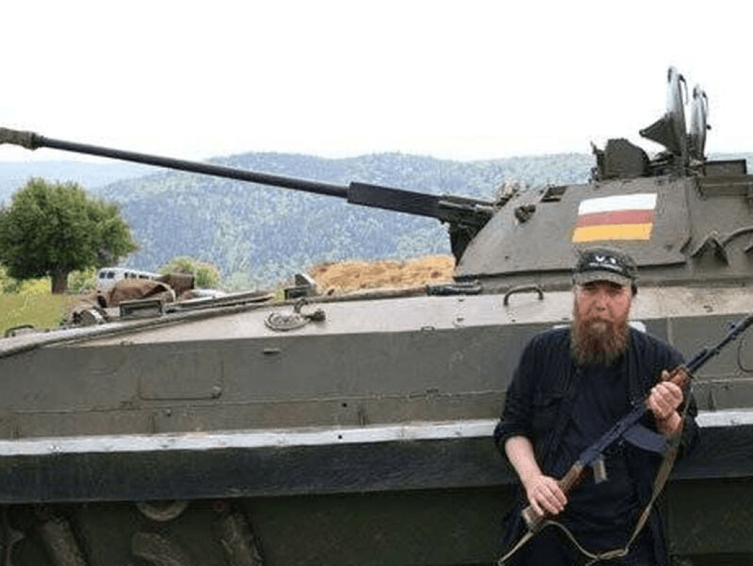 Dugin portando un arma recostado a un tanque de guerra.