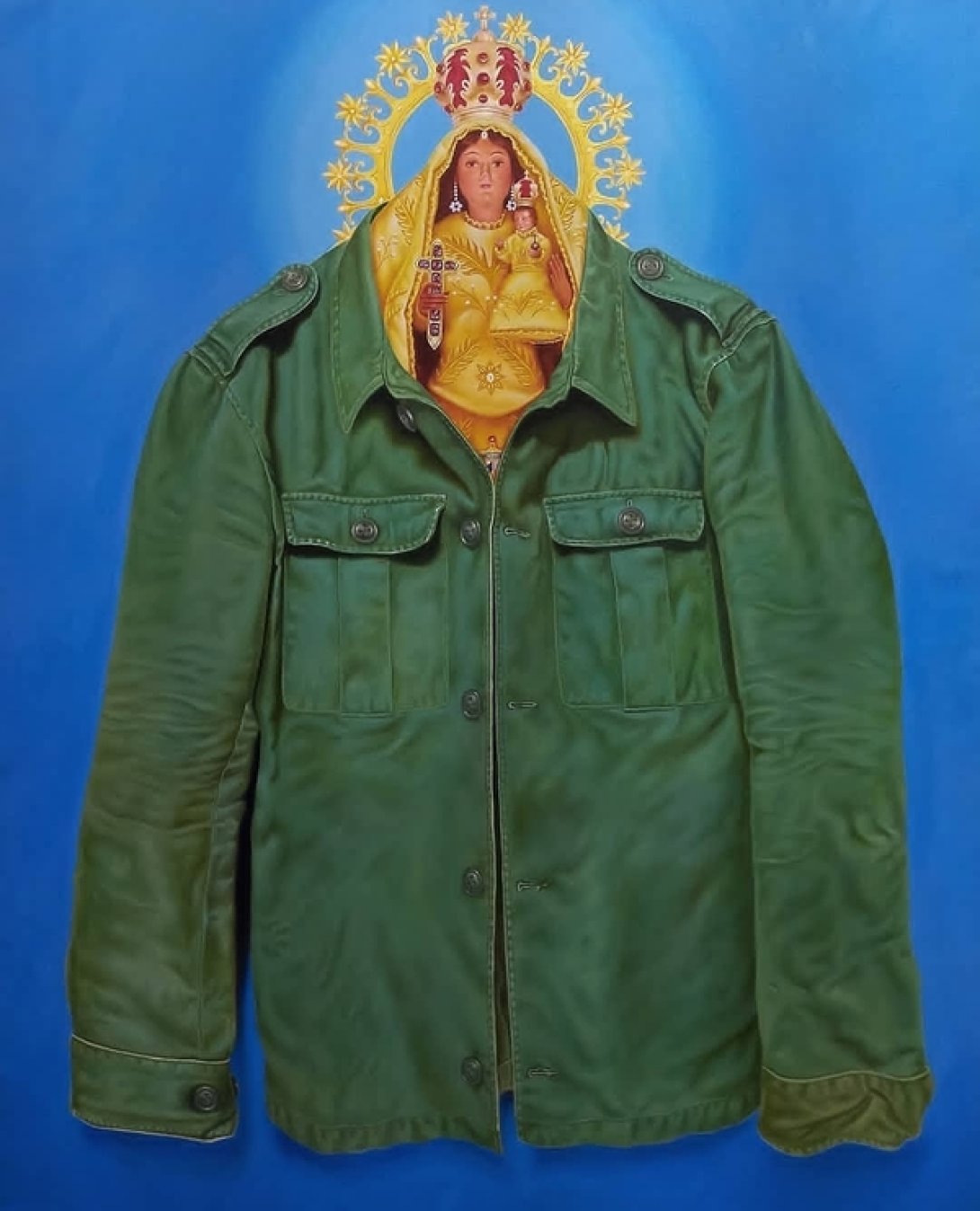 Estatuilla de la Virgen de la Caridad dentro de un traje verde militar.