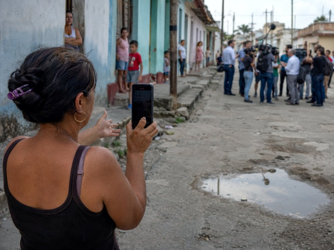Encuesta de Cuba Adentro. Una mujer en un pueblo del interior filma con su móvil.