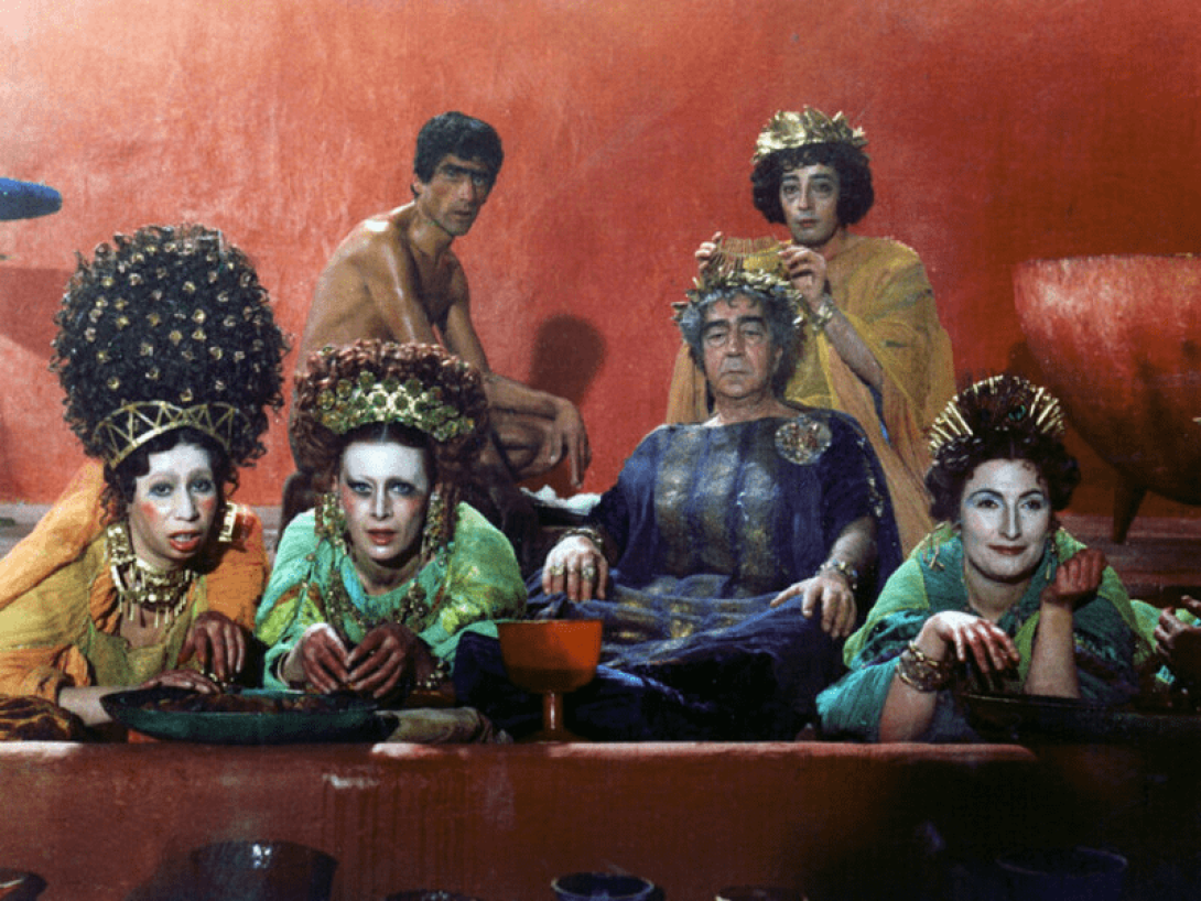 Grupo de personas con trajes suntuosos y caras pintadas.