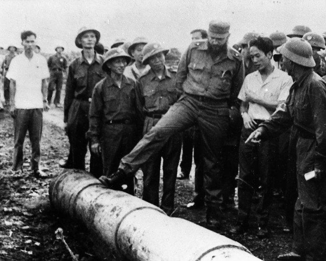 Fidel Castro rodeado de soldados vietnamitas mientras examina un proyectil en Quang Tri durante su visita a Vietnam en 1973.