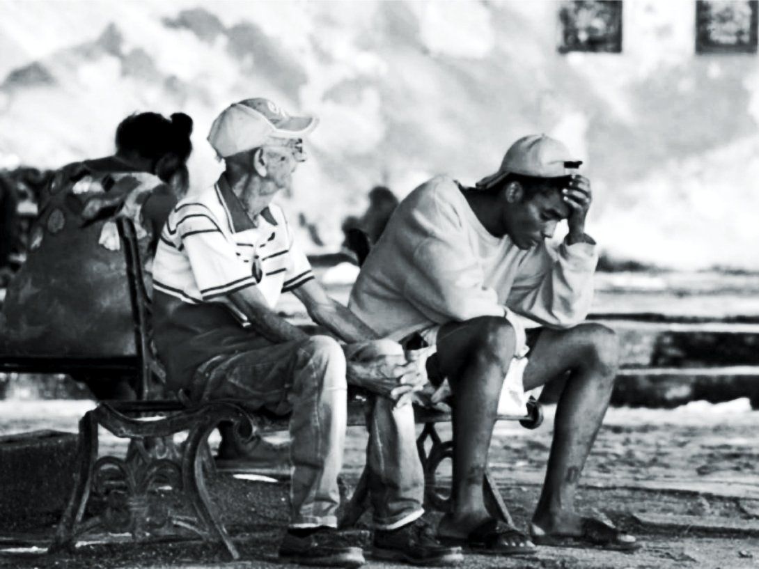 Cubanos sentados en un parque.