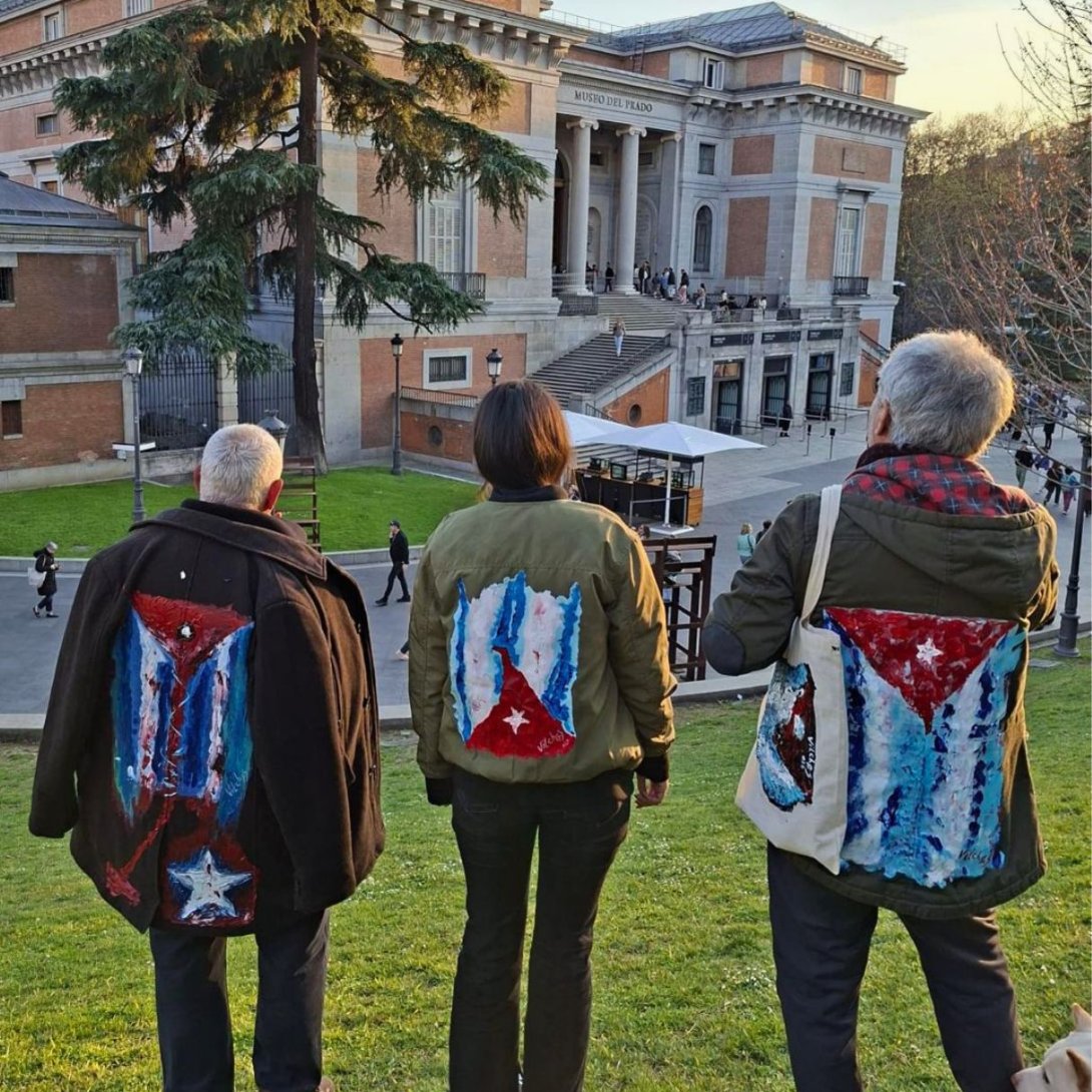 Performance "Mi bandera" del artista cubano exiliado Rafael Vilches, junto al artivista Rigoberto Carceller y Lola Carceller. Frente al Museo del Prado (23 de marzo de 2026). Foto de Ana Rosa Díaz Naranjo.