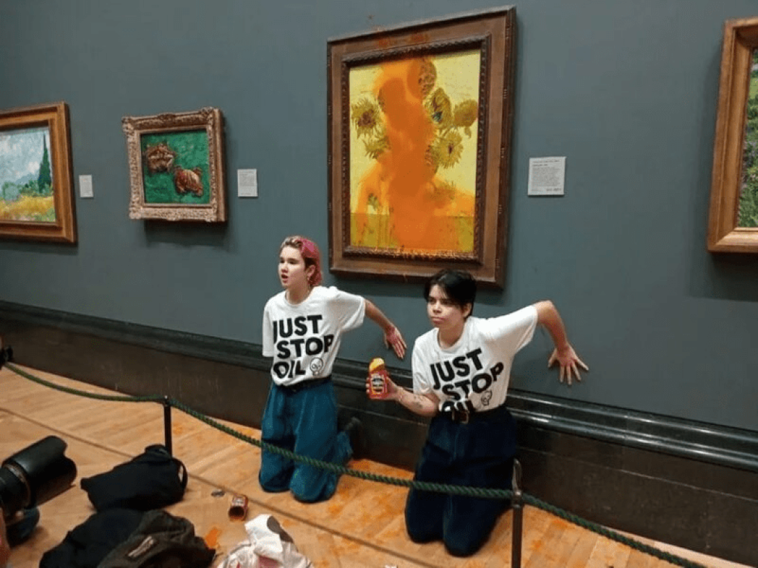 Personas protestando por el cambio climático junto al cuadro "Los girasoles", de Van Gogh.