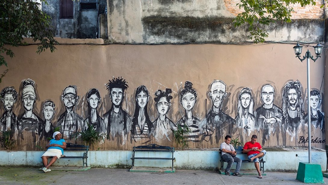 Grafiti que muestra a un grupo de personas en una pared habanera