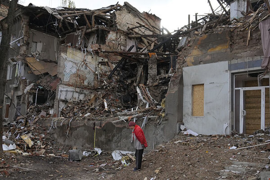 Una anciana observa el estado destruido de un edificio en Ucrania