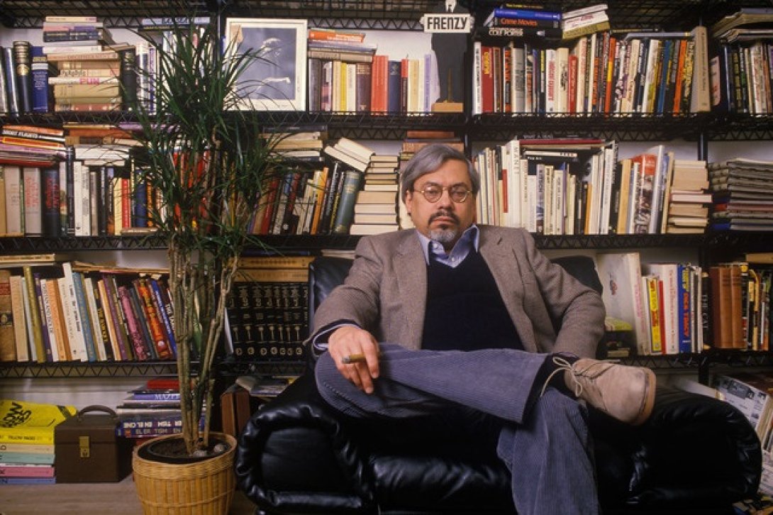 El escritor Guillermo Cabrera Infante en una biblioteca