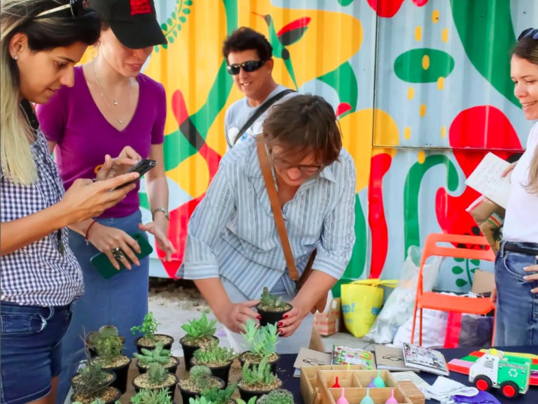 Personas en un bazar alrededor de plantas.
