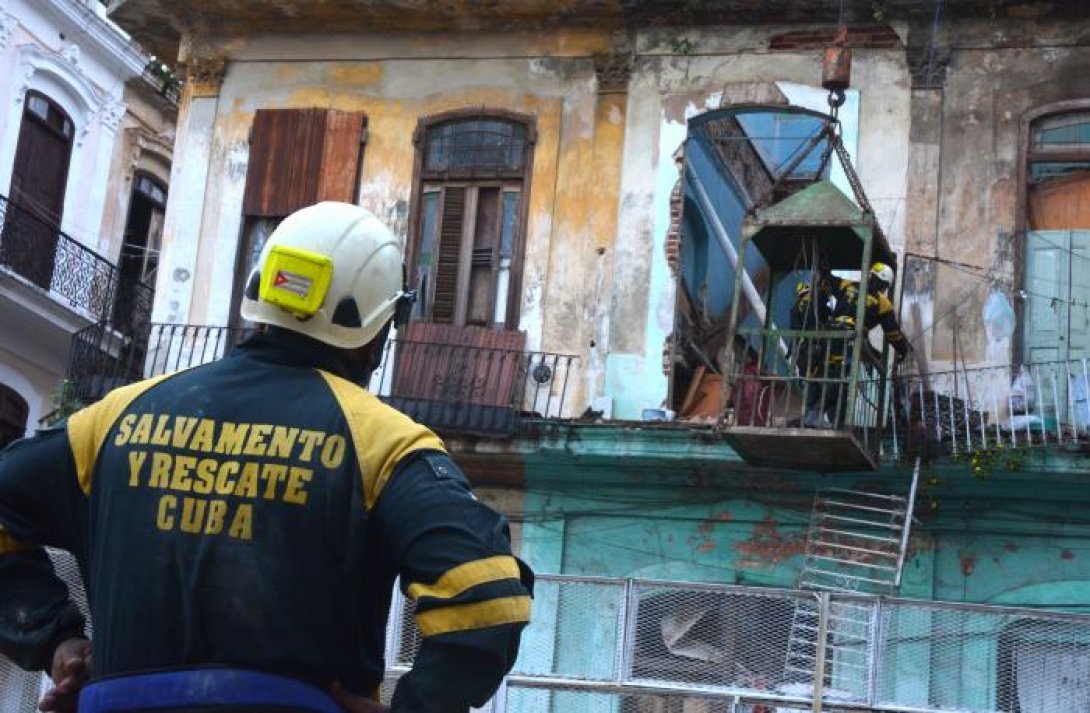 Un miembro de la brigada de rescatistas observa el edificio derrumbado.