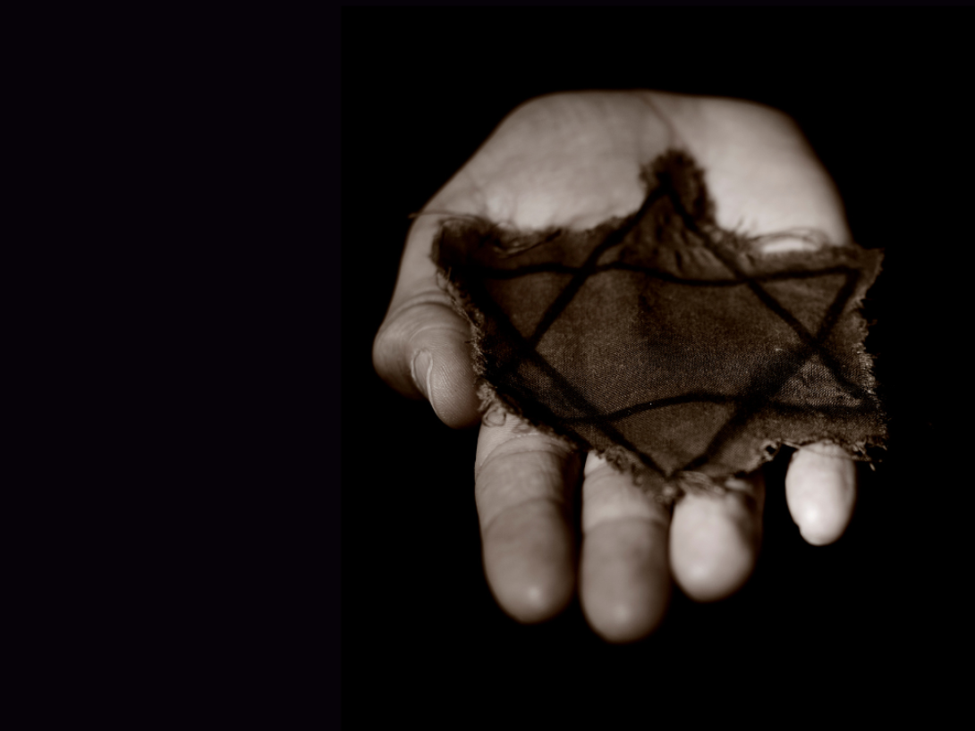 Mano muestra un pedazo de tela quemado con la Estrella de David, símbolo judío.