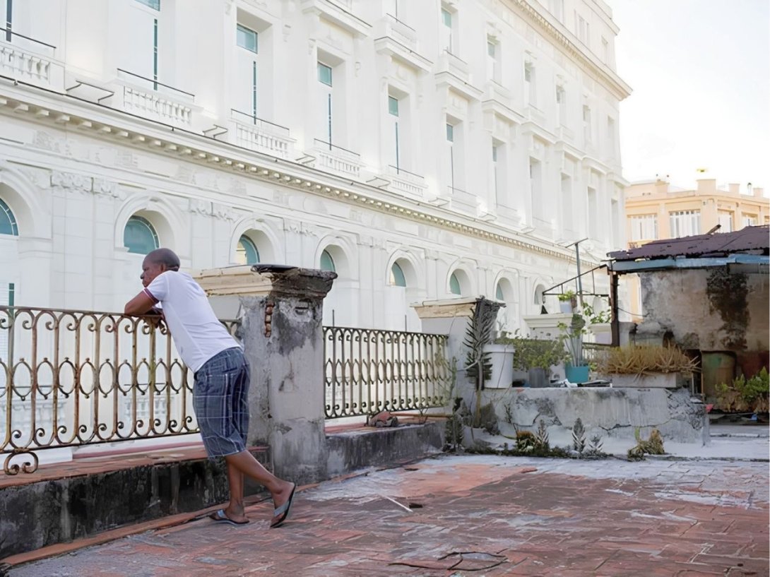 Cubano observando el Gran Hotel Manzana Kempinski, La Habana. Foto: Lisette Poole / The New York Times.