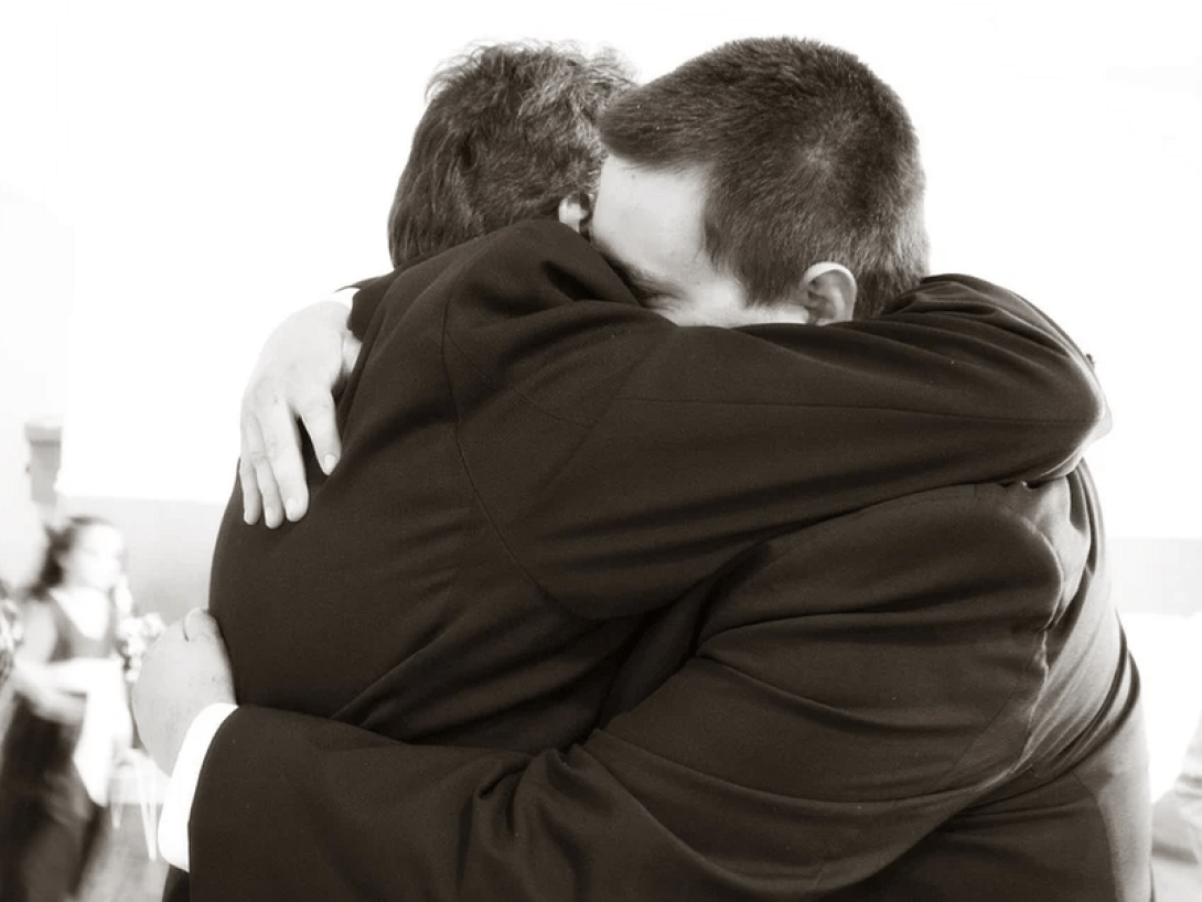 Dos personas abrazándose.