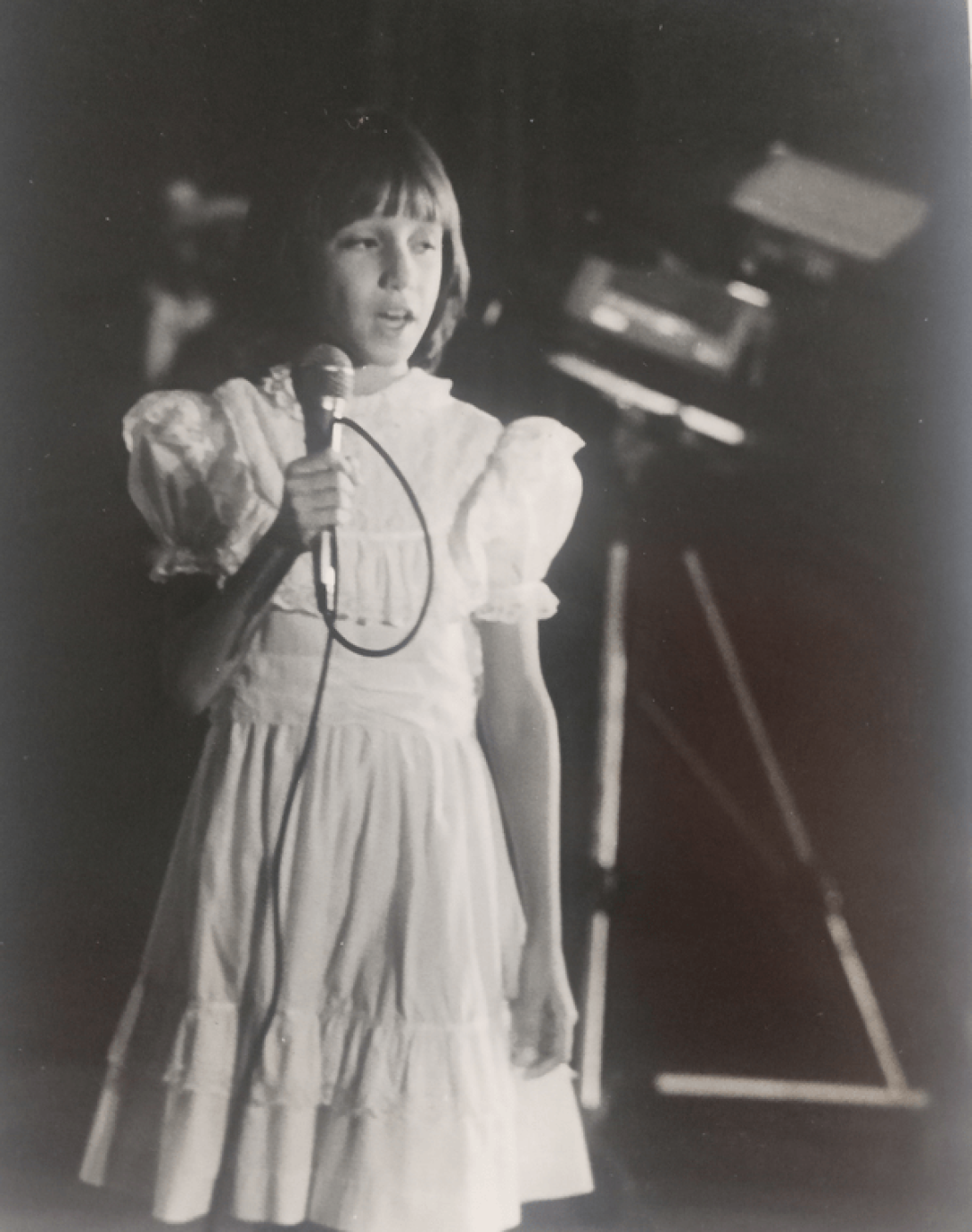 Liliam OJeda de niña cantando en el teatro.