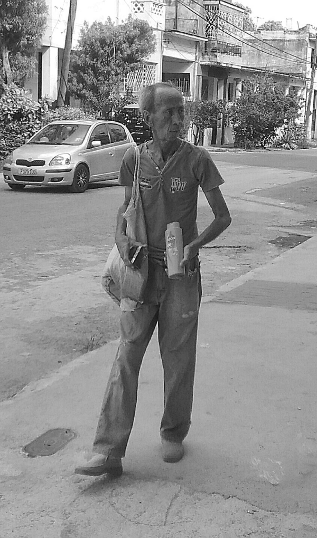 Hombre de aspecto pobre caminando por las calles cubanas.