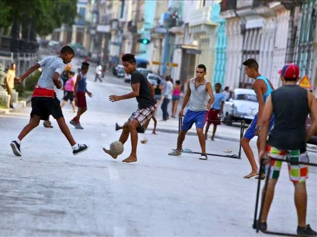 Jóvenes cubanos jugando fútbol en las calles de La Habana. Foto de EFE.