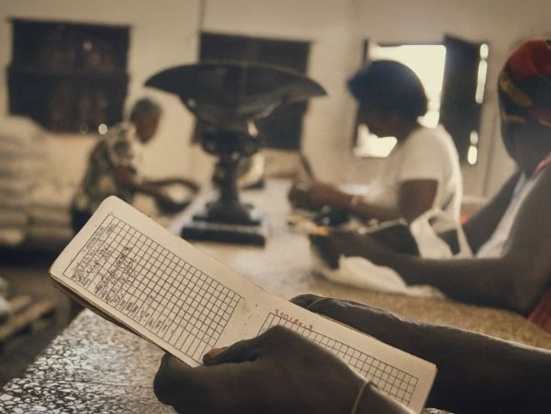 Mano de un consumidor sostiene su libreta de abastecimiento en una bodega cubana, mientras espera el pesaje de productos normados.