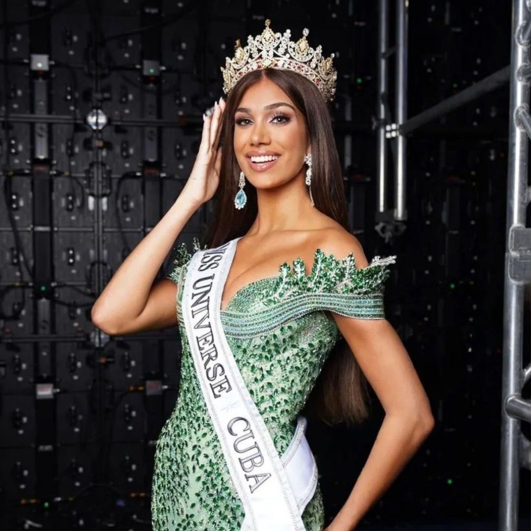 Lina Luaces, coronada como Miss Universo Cuba 2025, sonríe mientras posa con la banda Miss Universe Cuba y una corona dorada, luciendo un vestido verde con detalles de pedrería.