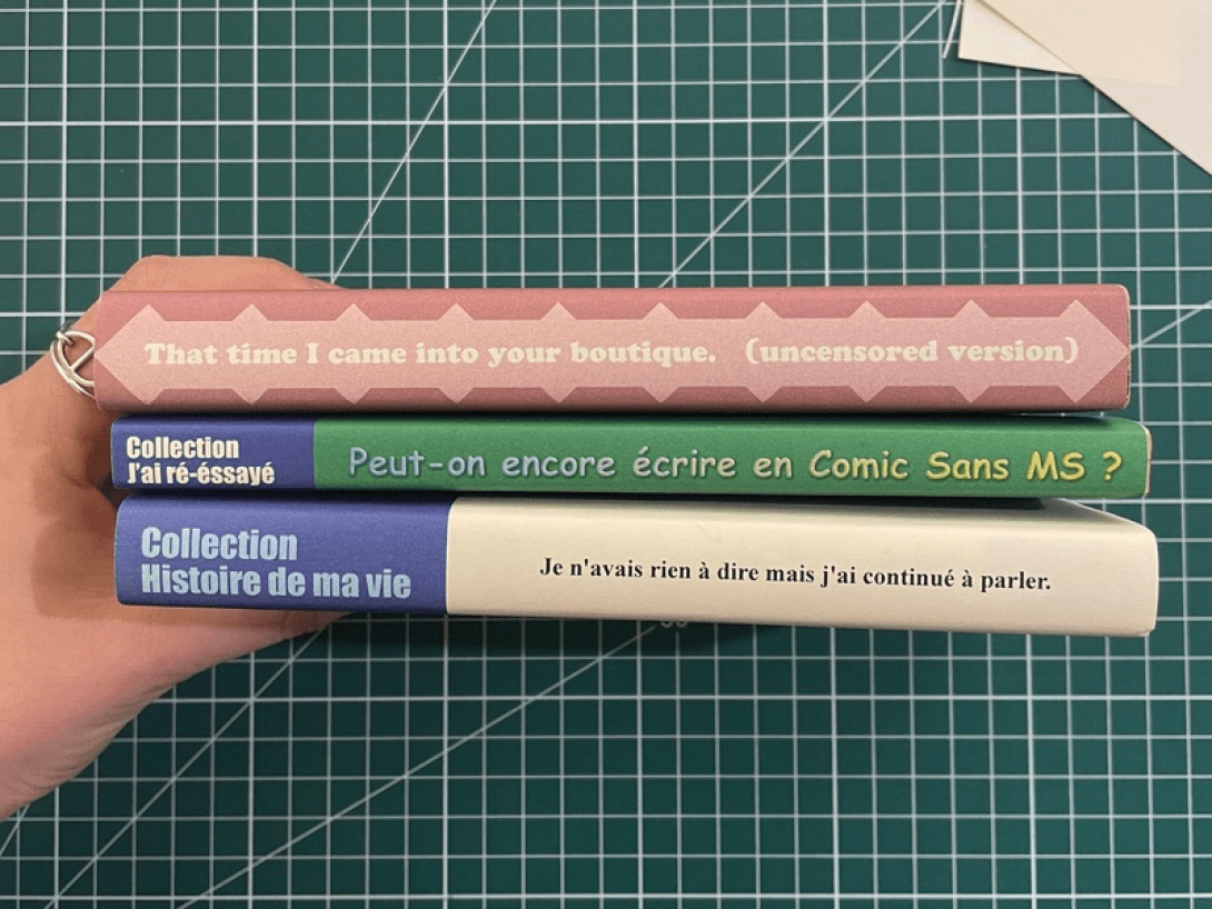 Tres libros, sostenidos por una mano, muestran sus lomos.
