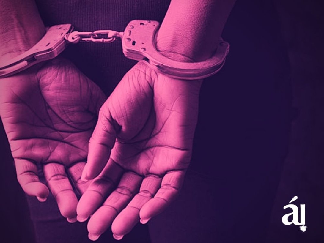 Manos de mujer esposadas. 